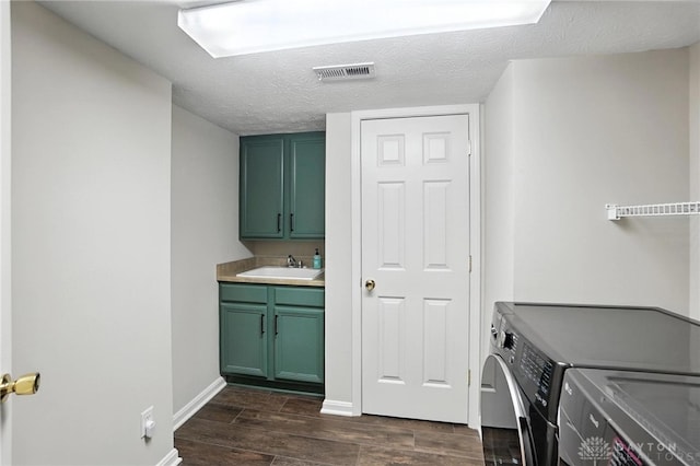 2210 Hidden Woods Blvd, Beavercreek, OH 45431 - washroom featuring separate washer and dryer, cabinet space, dark wood-style flooring, and a textured ceiling