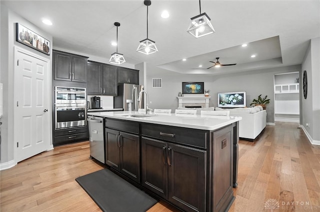 539 Bellasera Dr, Sugarcreek Twp, OH 45440 - kitchen featuring appliances with stainless steel finishes, a raised ceiling, light wood-style floors, light countertops, and recessed lighting