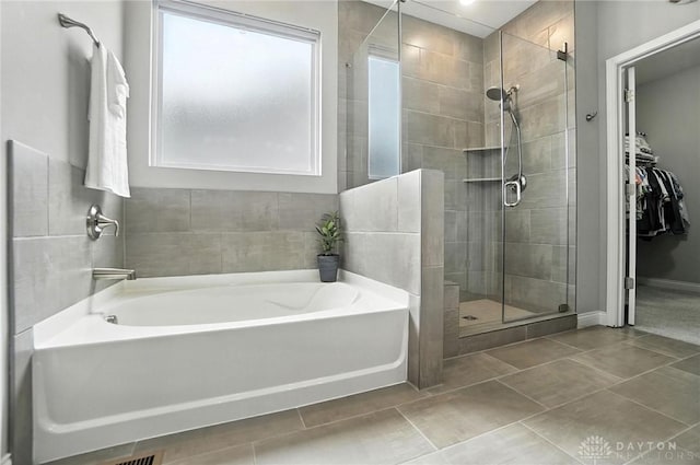 539 Bellasera Dr, Sugarcreek Twp, OH 45440 - bathroom with plenty of natural light, a garden tub, a shower stall, and tile patterned flooring