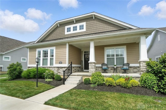 539 Bellasera Dr, Sugarcreek Twp, OH 45440 - view of front of house featuring covered porch, stone siding, and a front yard