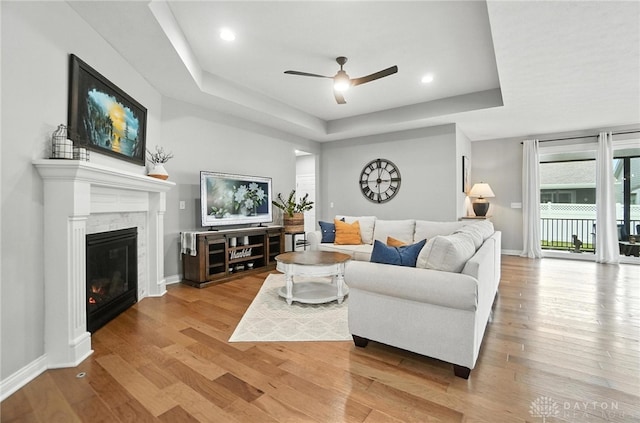 539 Bellasera Dr, Sugarcreek Twp, OH 45440 - living room with a raised ceiling, a glass covered fireplace, ceiling fan, wood finished floors, and recessed lighting