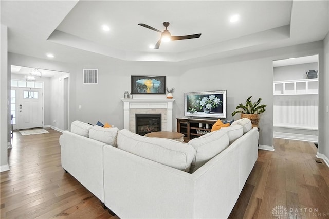 539 Bellasera Dr, Sugarcreek Twp, OH 45440 - living area featuring a tray ceiling, dark wood-style flooring, a ceiling fan, a glass covered fireplace, and recessed lighting