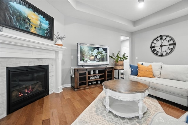 539 Bellasera Dr, Sugarcreek Twp, OH 45440 - living room featuring wood finished floors, a glass covered fireplace, and a raised ceiling