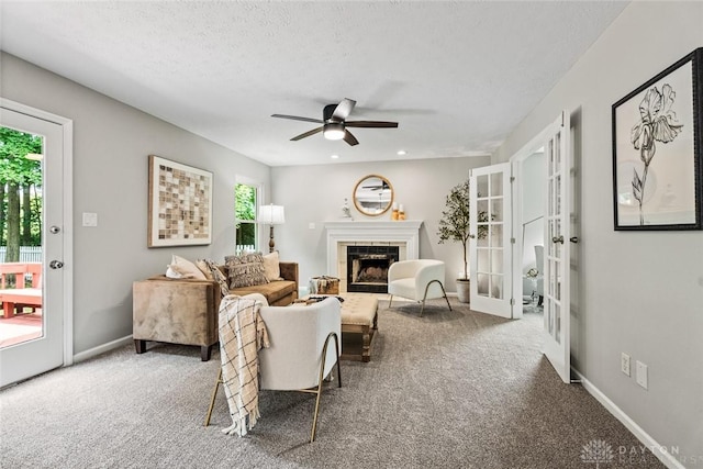4182 Fox Fern Ct, Beavercreek, OH 45432 - carpeted living area with healthy amount of natural light, a ceiling fan, a tiled fireplace, french doors, and a textured ceiling
