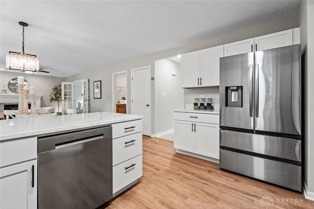 4182 Fox Fern Ct, Beavercreek, OH 45432 - kitchen with appliances with stainless steel finishes, white cabinetry, light countertops, and light wood-type flooring