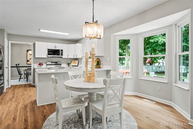 4182 Fox Fern Ct, Beavercreek, OH 45432 - dining space with a chandelier and light wood-style floors