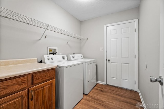 4182 Fox Fern Ct, Beavercreek, OH 45432 - laundry area with independent washer and dryer, wood finished floors, and cabinet space