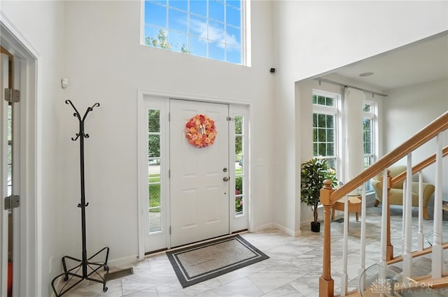 4546 Brackenview Ct, Mason, OH 45040 - entryway featuring plenty of natural light, light marble finish flooring, a high ceiling, and stairs