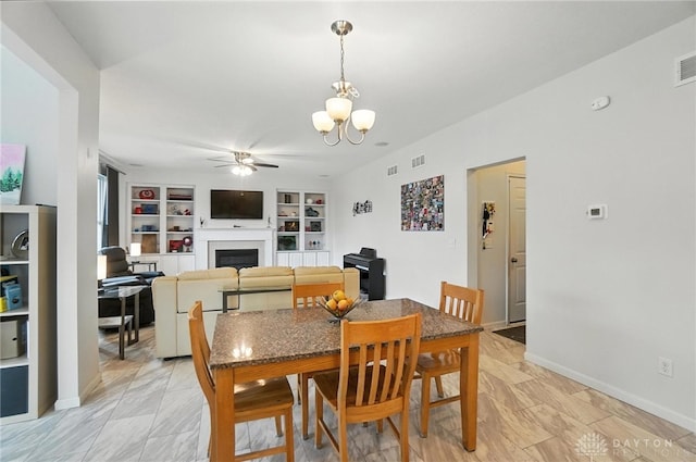 4546 Brackenview Ct, Mason, OH 45040 - dining space featuring a ceiling fan, a fireplace, a chandelier, and built in features