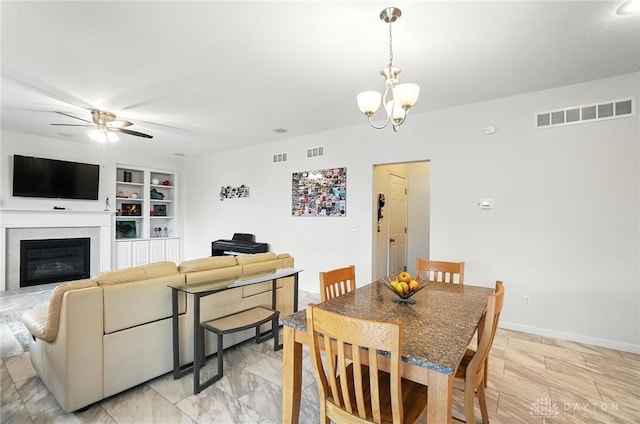 4546 Brackenview Ct, Mason, OH 45040 - dining area featuring a ceiling fan, built in shelves, a chandelier, and a tiled fireplace