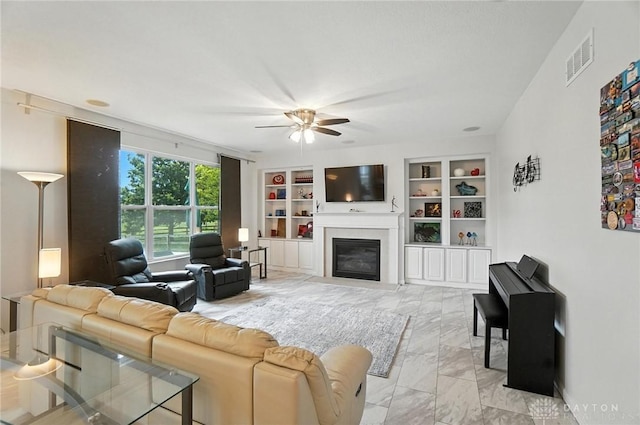 4546 Brackenview Ct, Mason, OH 45040 - living room featuring ceiling fan, a glass covered fireplace, built in shelves, and light marble finish floors