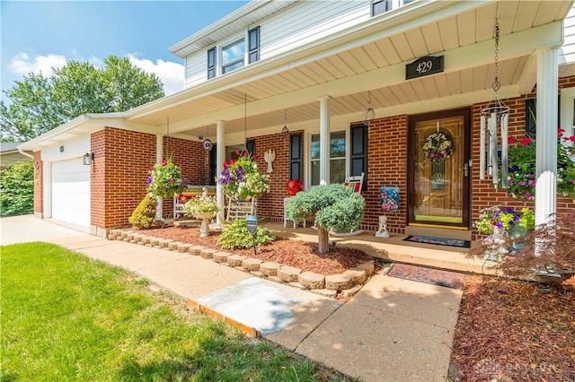 429 Rader Dr, Vandalia, OH 45377 - view of exterior entry featuring covered porch, brick siding, and an attached garage