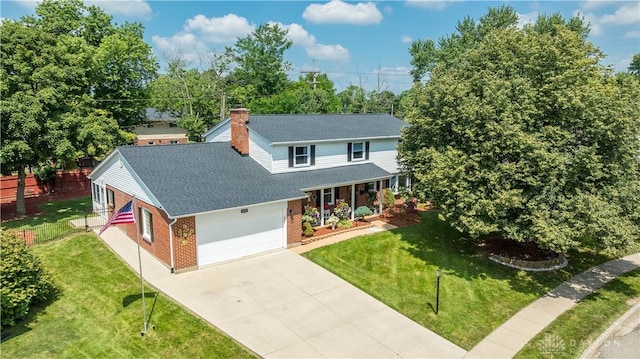 429 Rader Dr, Vandalia, OH 45377 - view of front facade featuring brick siding, roof with shingles, concrete driveway, an attached garage, and a chimney