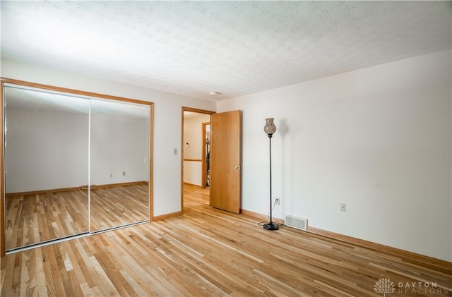 429 Rader Dr, Vandalia, OH 45377 - unfurnished bedroom with wood finished floors, a closet, and a textured ceiling