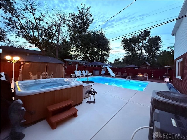 429 Rader Dr, Vandalia, OH 45377 - view of swimming pool with a hot tub, a water slide, a fenced backyard, and a patio