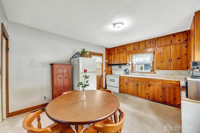 677 Ridgewood Ave, Hamilton, OH 45013 - kitchen with white appliances, light countertops, brown cabinetry, and under cabinet range hood