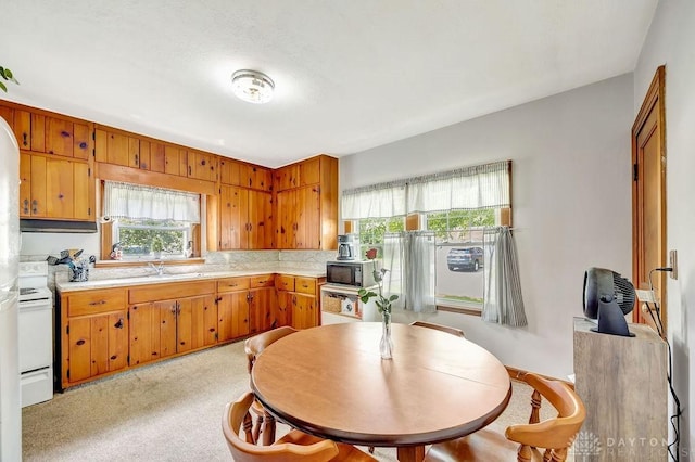 677 Ridgewood Ave, Hamilton, OH 45013 - kitchen with white range with electric cooktop, light countertops, black microwave, brown cabinets, and backsplash