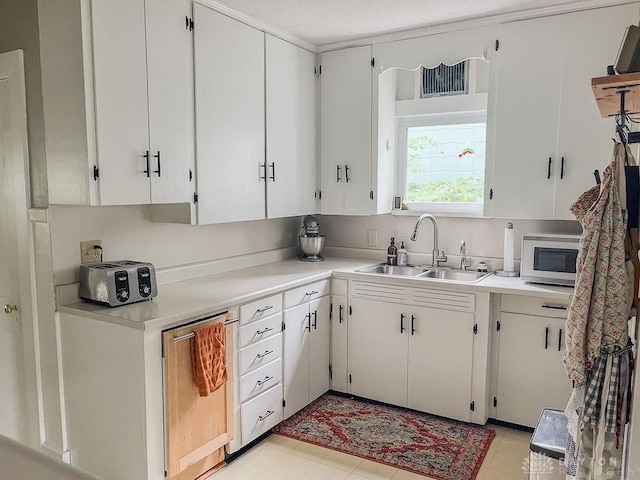 1110 E Main St, Troy, OH 45373 - kitchen with stainless steel microwave, light countertops, and white cabinetry