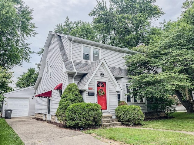 1110 E Main St, Troy, OH 45373 - view of front of house featuring driveway, a shingled roof, an outdoor structure, and a detached garage