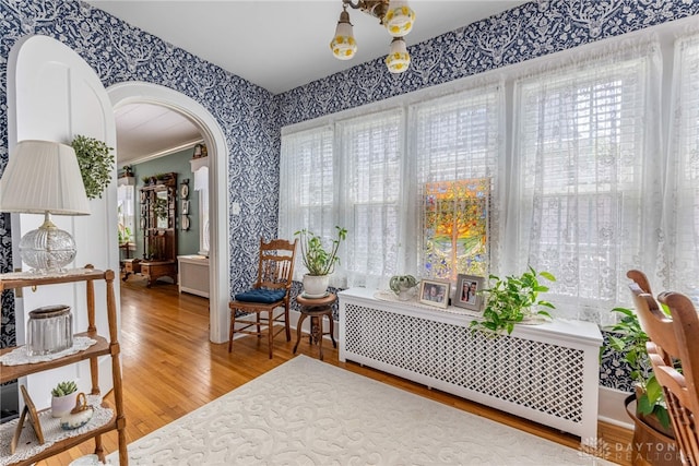 288 N King St, Xenia, OH 45385 - living area with wallpapered walls, arched walkways, wood finished floors, and radiator
