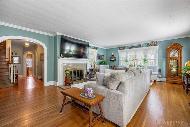288 N King St, Xenia, OH 45385 - living room with stairway, hardwood / wood-style floors, arched walkways, crown molding, and a glass covered fireplace