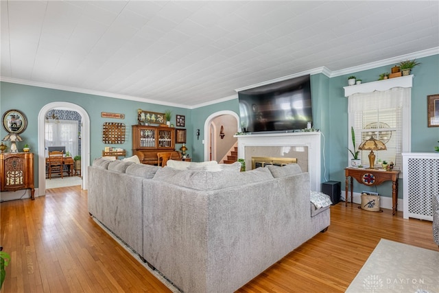 288 N King St, Xenia, OH 45385 - living area with arched walkways, light wood-type flooring, crown molding, and a glass covered fireplace