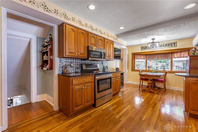 288 N King St, Xenia, OH 45385 - kitchen with appliances with stainless steel finishes, brown cabinetry, wood finished floors, decorative backsplash, and recessed lighting