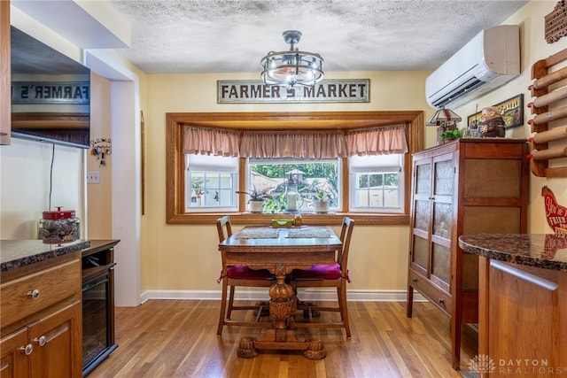 288 N King St, Xenia, OH 45385 - dining room with a wall unit AC, a textured ceiling, and light wood finished floors