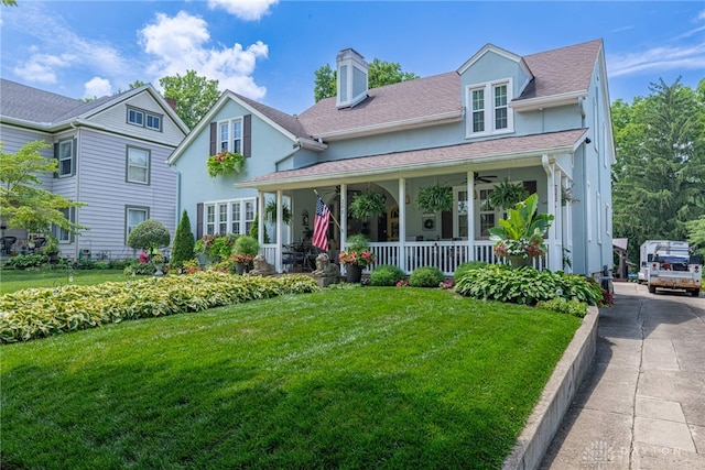 288 N King St, Xenia, OH 45385 - view of front of property featuring covered porch, a front lawn, stucco siding, a chimney, and roof with shingles