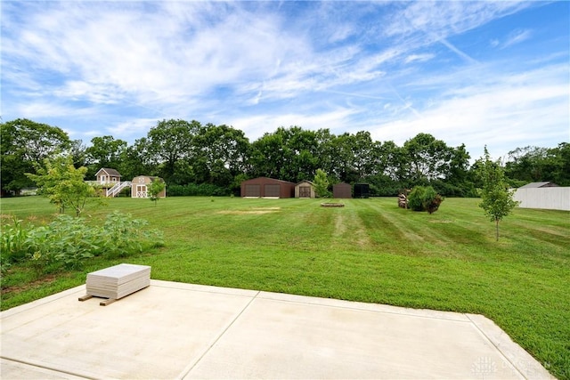 4095 N State Route 42, Waynesville, OH 45068 - view of green lawn featuring a patio, a storage unit, a detached garage, and view of scattered trees