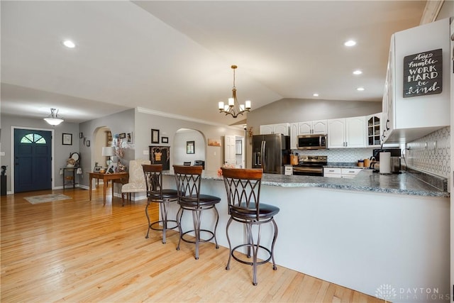 4095 N State Route 42, Waynesville, OH 45068 - kitchen featuring appliances with stainless steel finishes, arched walkways, white cabinetry, a peninsula, and light wood-style flooring