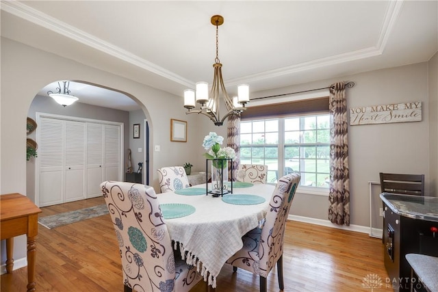 4095 N State Route 42, Waynesville, OH 45068 - dining area featuring arched walkways, a chandelier, light wood-style flooring, ornamental molding, and a tray ceiling