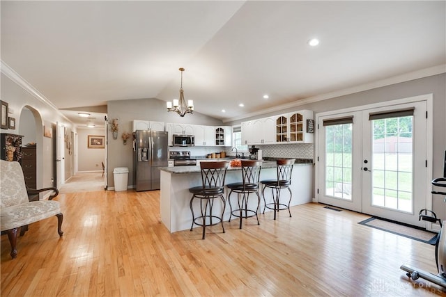 4095 N State Route 42, Waynesville, OH 45068 - kitchen with stainless steel appliances, glass insert cabinets, a kitchen breakfast bar, ornamental molding, and white cabinetry