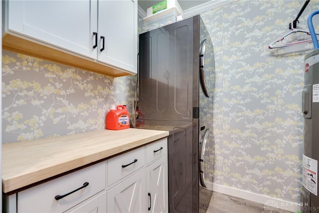 4095 N State Route 42, Waynesville, OH 45068 - laundry area with estacked washer and dryer, cabinet space, wood finished floors, water heater, and wallpapered walls