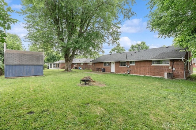2227 Los Arrow Dr, Dayton, OH 45439 - view of grassy yard with a fire pit and a storage shed