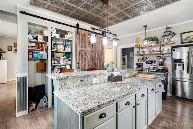 213 N Broadway St, Blanchester, OH 45107 - kitchen with stainless steel refrigerator with ice dispenser, a barn door, wood finished floors, light stone countertops, and open shelves