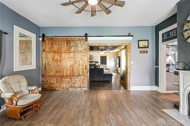 213 N Broadway St, Blanchester, OH 45107 - sitting room with wood finished floors, a ceiling fan, and a barn door