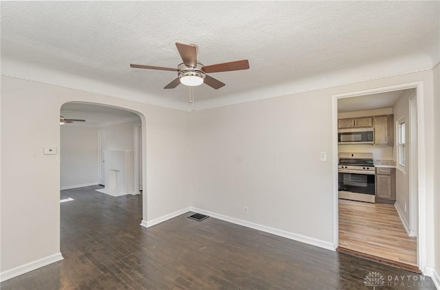 1337 Shepherd Ln, Hamilton, OH 45215 - unfurnished room featuring ceiling fan, arched walkways, dark wood-style flooring, and a textured ceiling