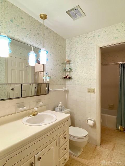 9476 Sheehan Rd, Dayton, OH 45458 - bathroom featuring wallpapered walls, vanity, shower / bath combo with shower curtain, and tile walls