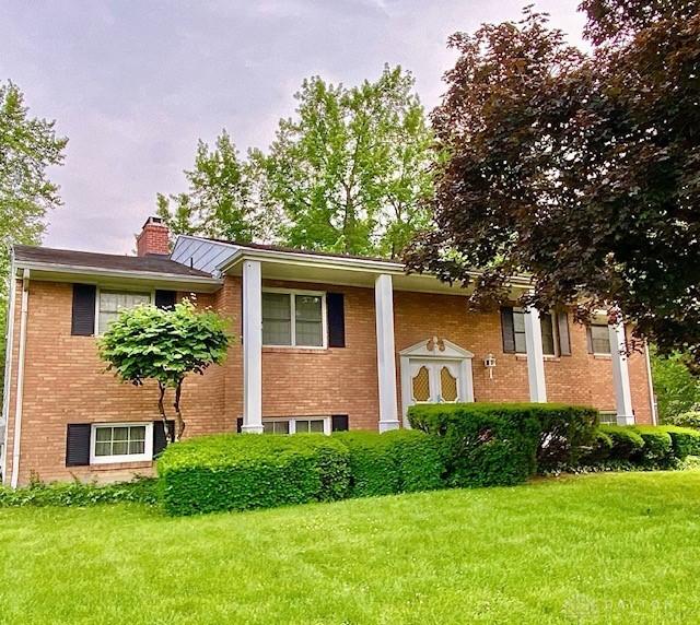 9476 Sheehan Rd, Dayton, OH 45458 - view of front of property featuring brick siding, a front lawn, and a chimney