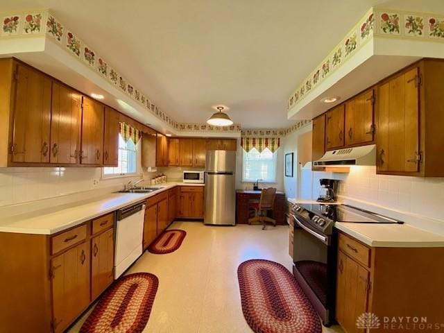 9476 Sheehan Rd, Dayton, OH 45458 - kitchen with white appliances, under cabinet range hood, brown cabinets, and light countertops