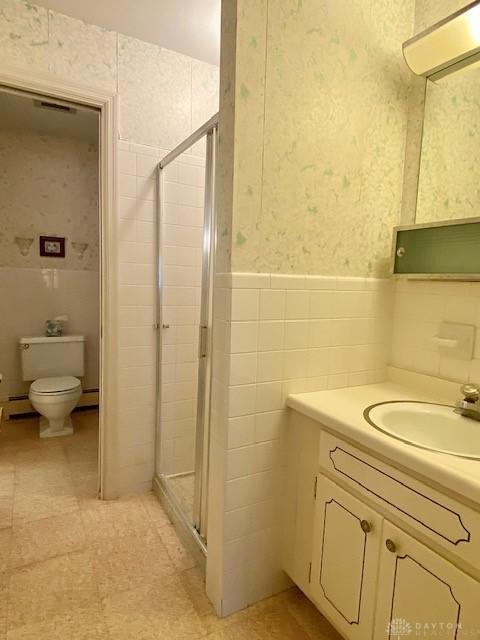 9476 Sheehan Rd, Dayton, OH 45458 - bathroom featuring tile walls, vanity, a stall shower, wallpapered walls, and wainscoting