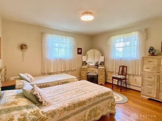 9476 Sheehan Rd, Dayton, OH 45458 - bedroom with a baseboard heating unit and wood finished floors