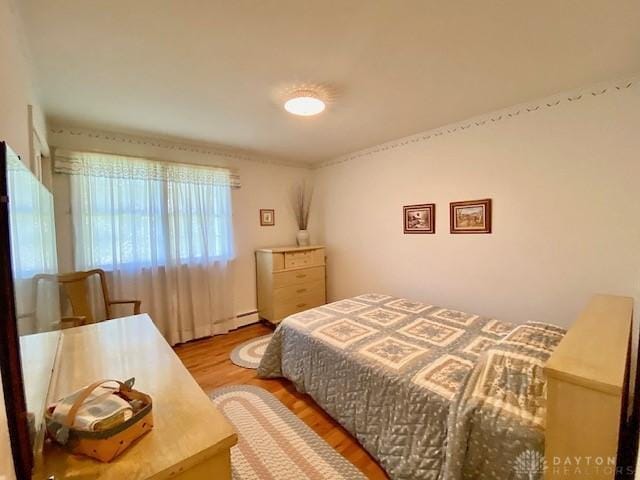 9476 Sheehan Rd, Dayton, OH 45458 - bedroom featuring light wood-type flooring and a baseboard heating unit
