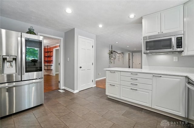 1572 Frontier Ct, Dayton, OH 45458 - kitchen featuring appliances with stainless steel finishes, light countertops, white cabinets, recessed lighting, and tile patterned flooring