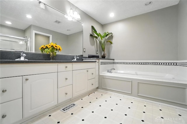 1572 Frontier Ct, Dayton, OH 45458 - bathroom with double vanity, a textured ceiling, a bath, a shower stall, and recessed lighting