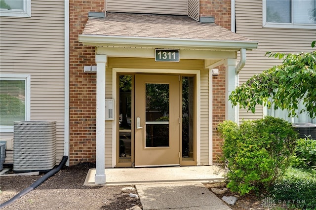 1311 Hollow Run Unit 6, Dayton, OH 45459 - doorway to property featuring roof with shingles and brick siding