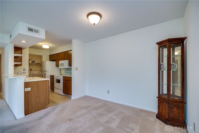 1311 Hollow Run Unit 6, Dayton, OH 45459 - kitchen featuring white appliances, light colored carpet, light countertops, a peninsula, and open shelves