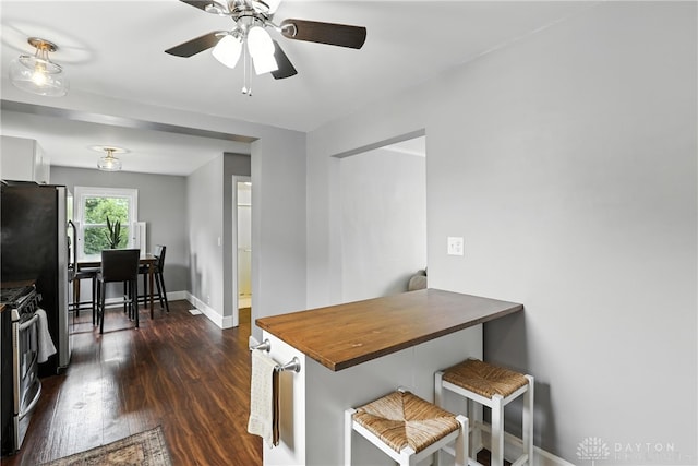 2594 Laura Ln, Norwood, OH 45212 - kitchen featuring stainless steel appliances, dark wood-style floors, ceiling fan, and a kitchen bar