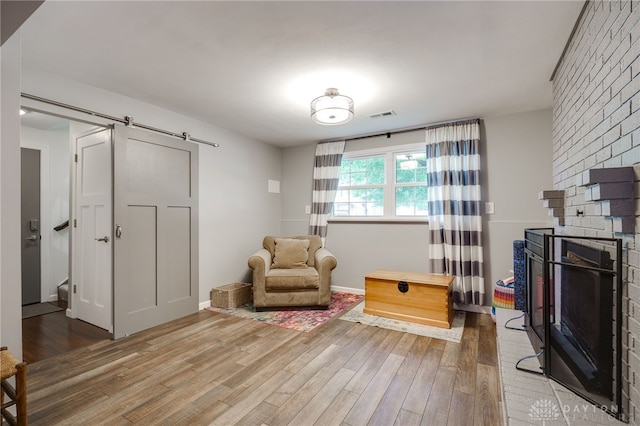 1817 El Camino Dr, Xenia, OH 45385 - sitting room featuring light wood-style flooring, a fireplace, and a barn door